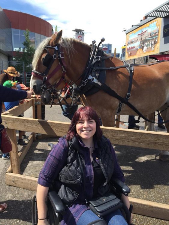 woman in wheelchair next to horse