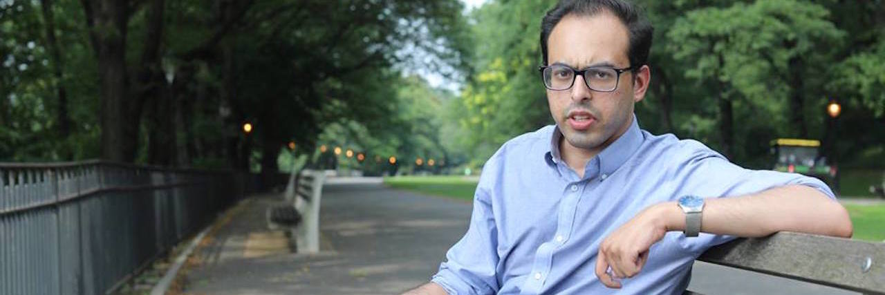 Resident Has Perfect Answer to Whether Mental Illness Impairs Work A man sitting on a blench. He's wearing glasses
