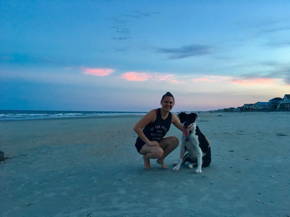 woman and her dog on the beach at dusk