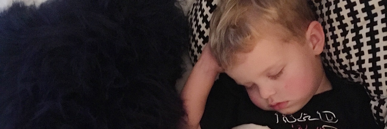 What It's Like to Parent a Child with Periodic Fever Syndrome the author's boy snuggled in bed