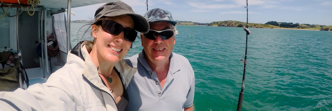 How to Move Forward After Losing Your Chronic Illness Buddy A picture of a young woman and older man on a boat, standing next to a fishing pole.