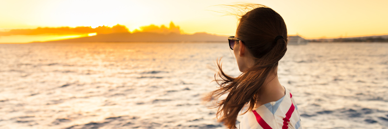 What I Would Tell Myself When I Was First Diagnosed With CRPS/RSD woman standing on a boat looking at sunset