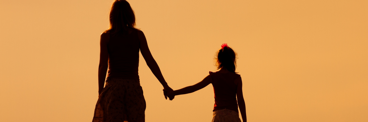 Mother and daughter enjoy watching sunset together.