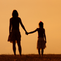 Mother and daughter enjoy watching sunset together.
