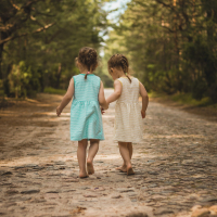 Two little girls on a forest road.