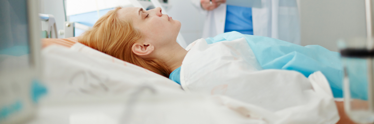 How to Prepare for Your Upcoming Endometriosis Surgery A picture of a woman laying in a hospital bed, with a doctor looking at her medical records.