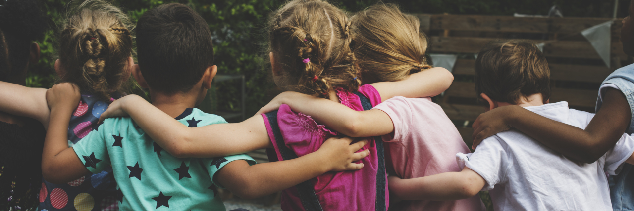 Tips for Helping Raise an Inclusive Child Group of kindergarten kids friends arm around sitting together