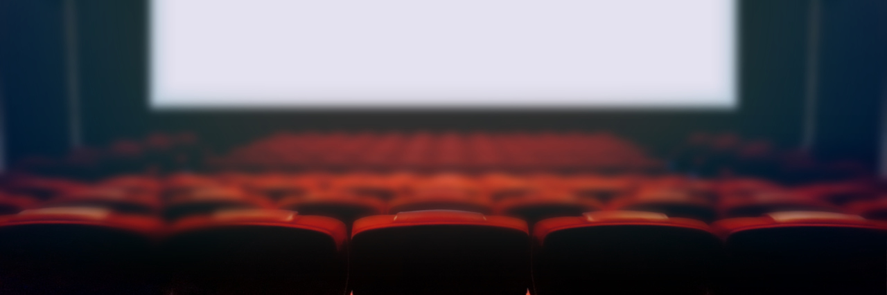 Empty movie cinema seats with blank wide white screen.