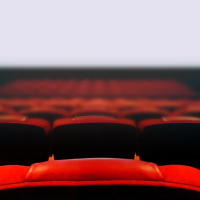 Empty movie cinema seats with blank wide white screen.