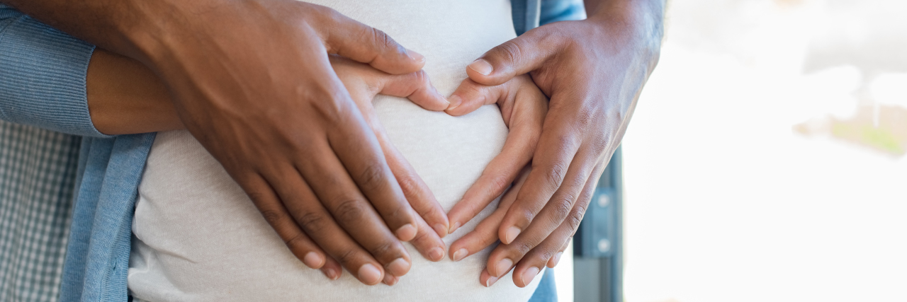 Pregnancy Considerations With Epilepsy Multiethnic couple expecting a baby.