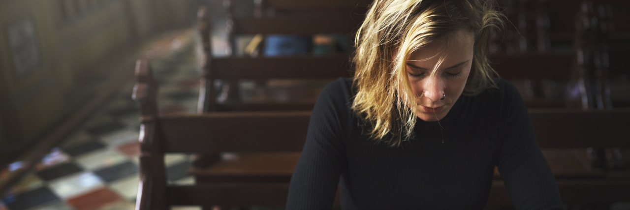 What God's Grace Means to Me as Someone With Chronic Migraine woman praying in church