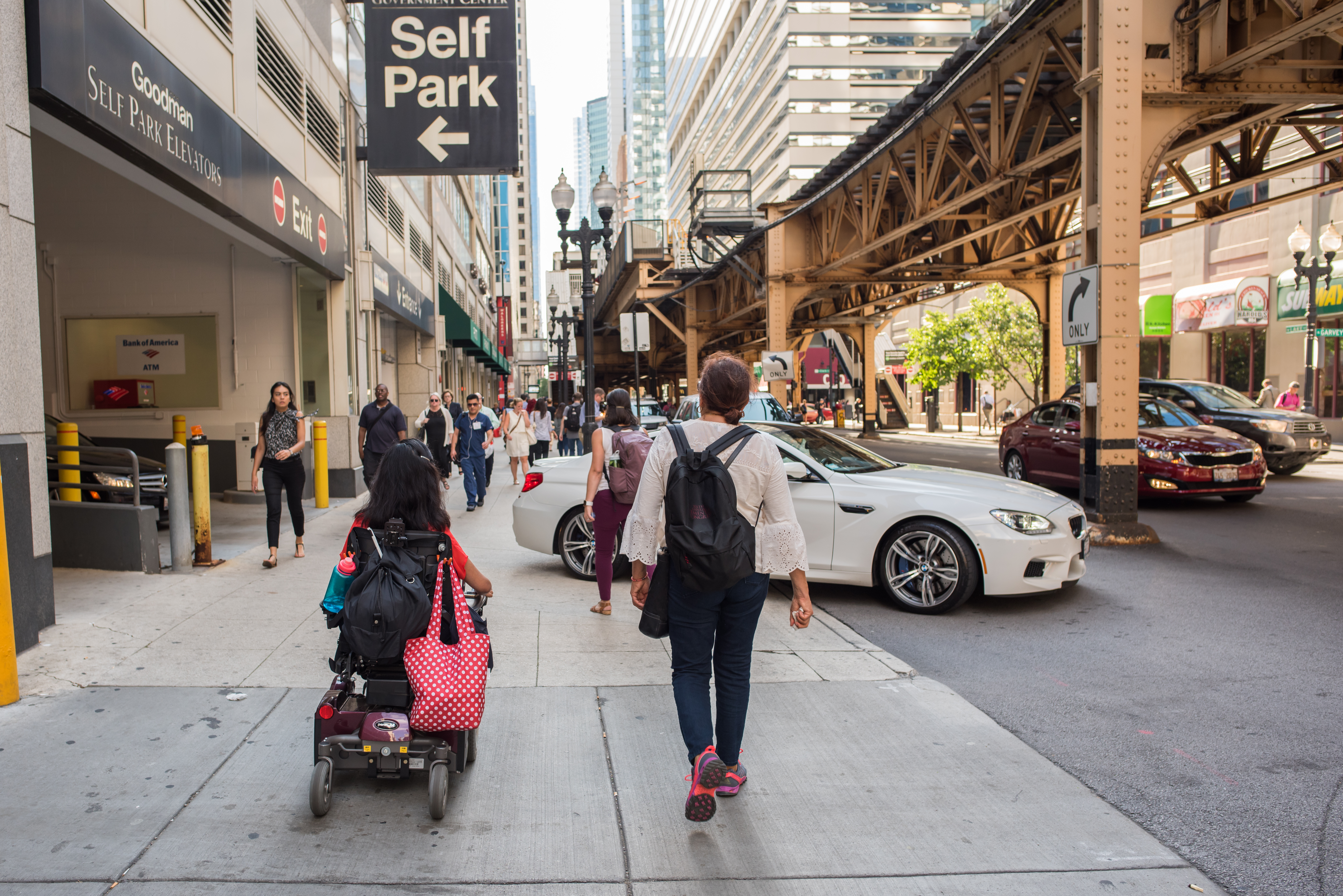 Chicago, IL, August 9, 2017: A woman rides a motorized wheelchair along the sidewalk downtown. Chicago is a very pedestrian friendly city with wide streets and accessible public transit