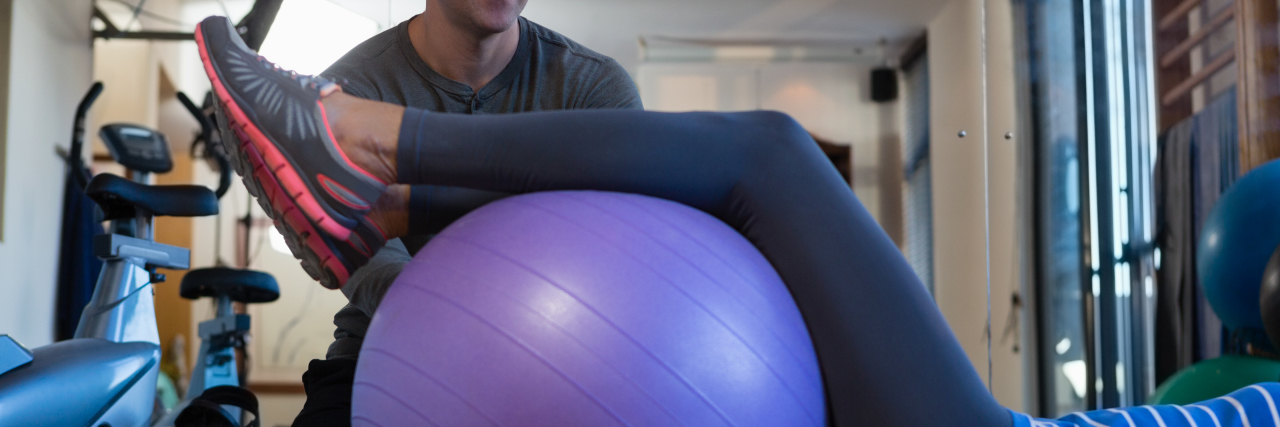 Exercising With Cerebral Palsy Physiotherapist assisting woman with exercise.