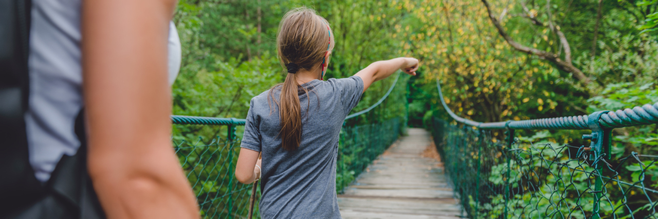 Why Summertime Holidays Aren't Easier for My Chronic Pain A mother and daughter walking in a forest.