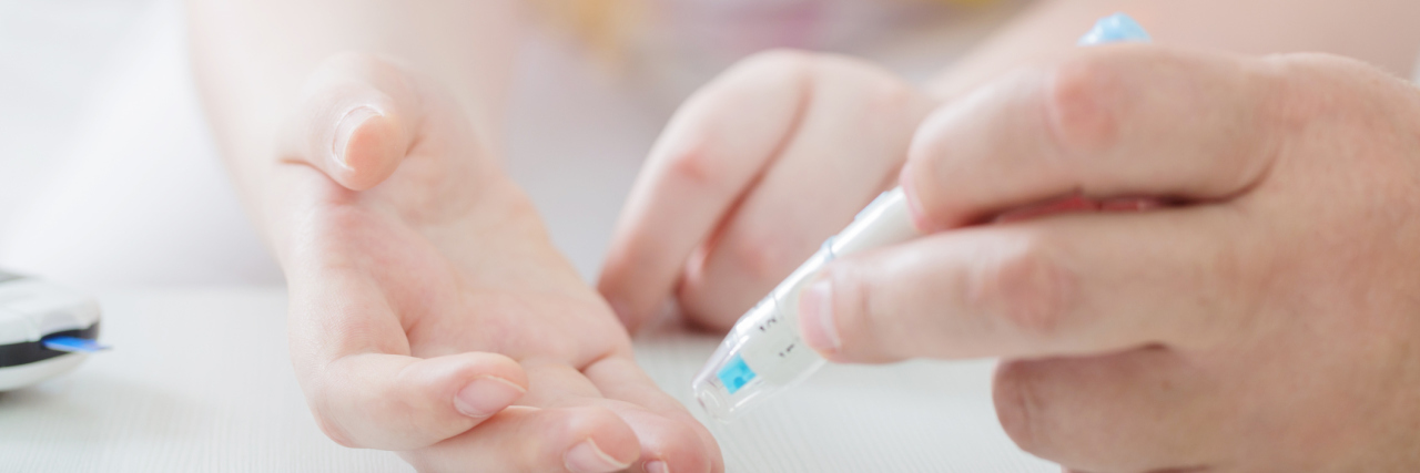 The Problematic Misconceptions Surrounding Childhood Diabetes A young girl testing glucose levels.