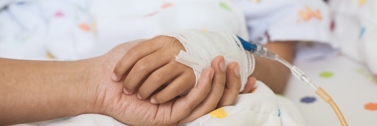 Letter to Parents Whose Child Is in the Hospital mother holding daughter's hand in the hospital