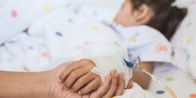 mother holding daughter's hand in the hospital