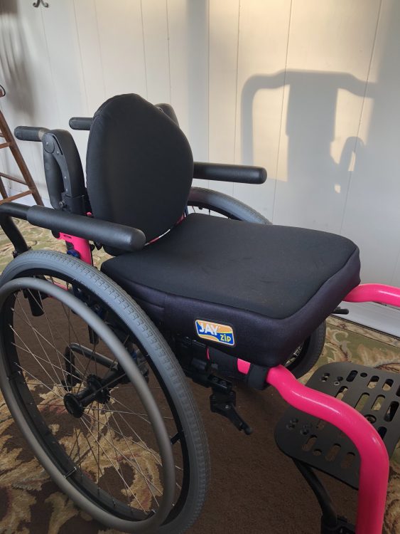 A pink and black wheelchair