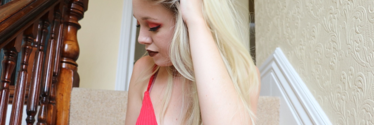 The Challenges of Dating With Chronic Pain the author looking to the side, sitting on steps