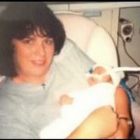 author's mom holding her as a baby in the hospital