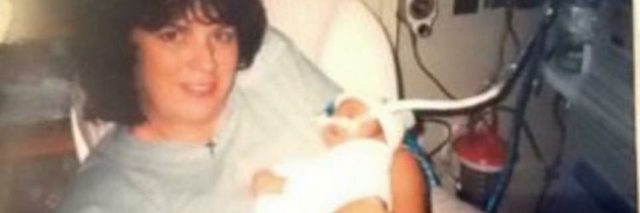 author's mom holding her as a baby in the hospital