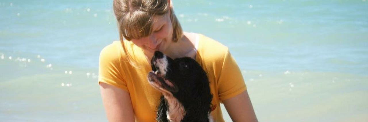 Woman on the beach with her Springer spaniel.