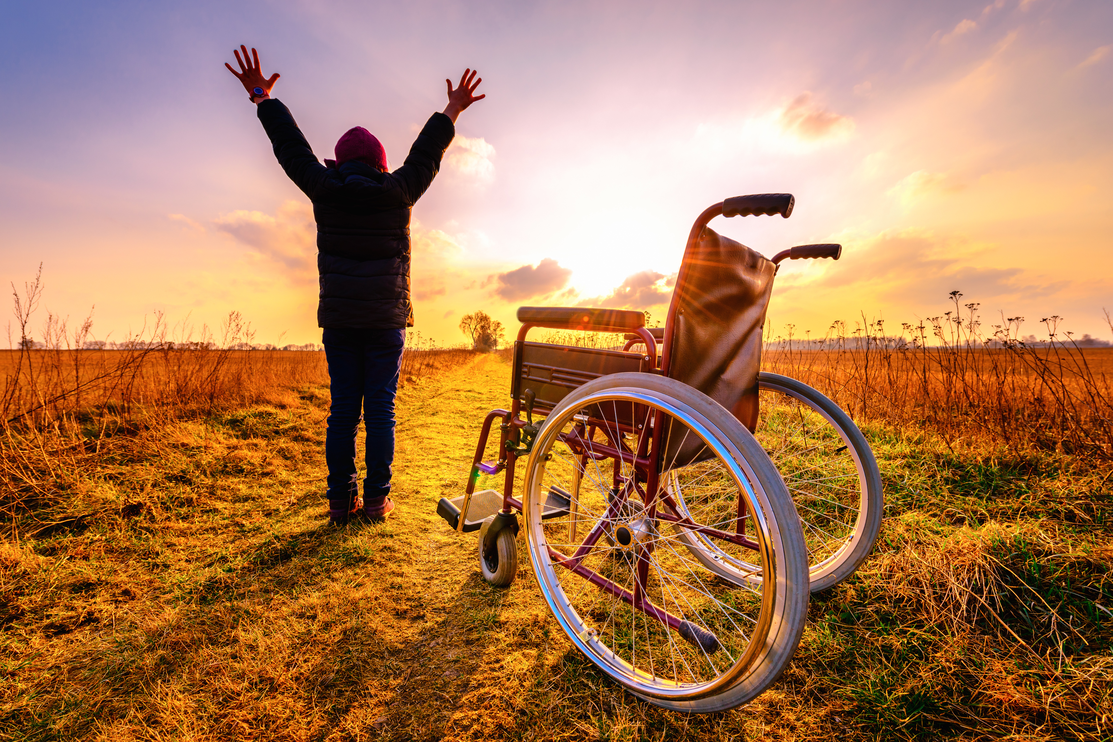 Woman standing next to wheelchair as if miraculously cured.