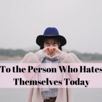 A woman making a heart with her hands. To the person who hates themselves today