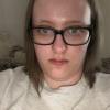 woman taking a selfie wearing glasses and a gray t-shirt