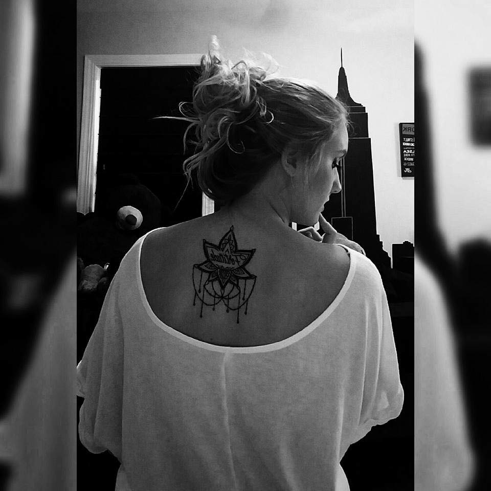 black and white photo of lotus flower tattoo on woman's upper back