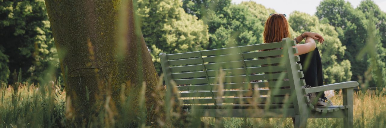Why 'Victim' Describes My Experience of Childhood Sexual Abuse woman sitting on bench in park in front of tree