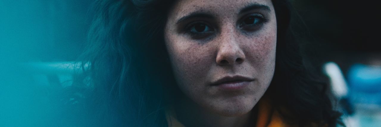 Disability and Chronic Illness Stereotypes in College close up photo of young woman looking sad wearing yellow hoodie
