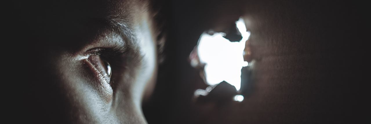 Why Not to Go to a Sick Friend's House Without Warning man looking through hole in wall
