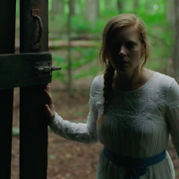 Camille opening the door to the shed in the woods