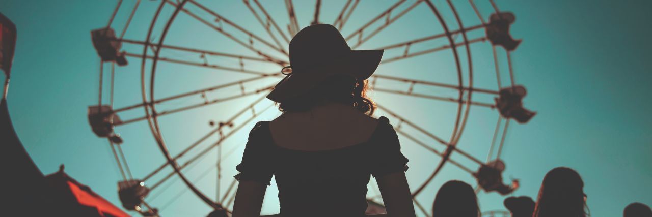 woman standing in front of a ferris wheel