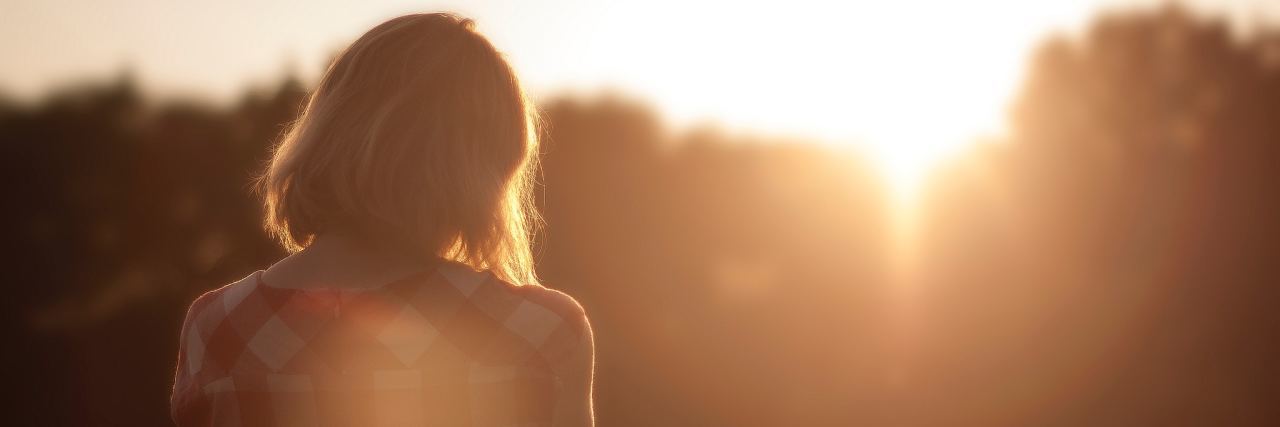 young woman at sunset with trees