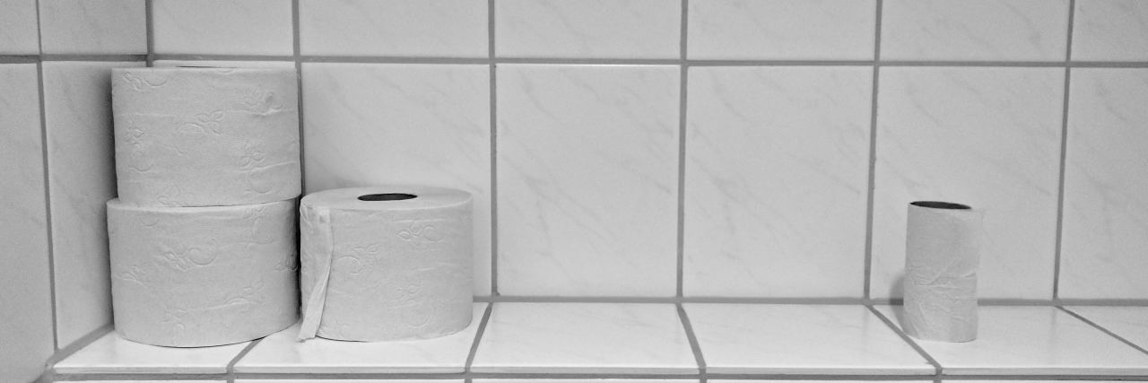 toilet paper on a bathroom shelf