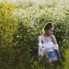 young woman sitting in meadow looking upset