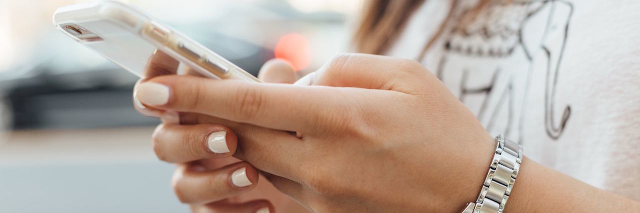 14 Things to Do on Your Phone When You're Having Suicidal Thoughts woman on her phone