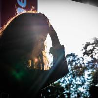 woman putting hand on her head framed by sunny window