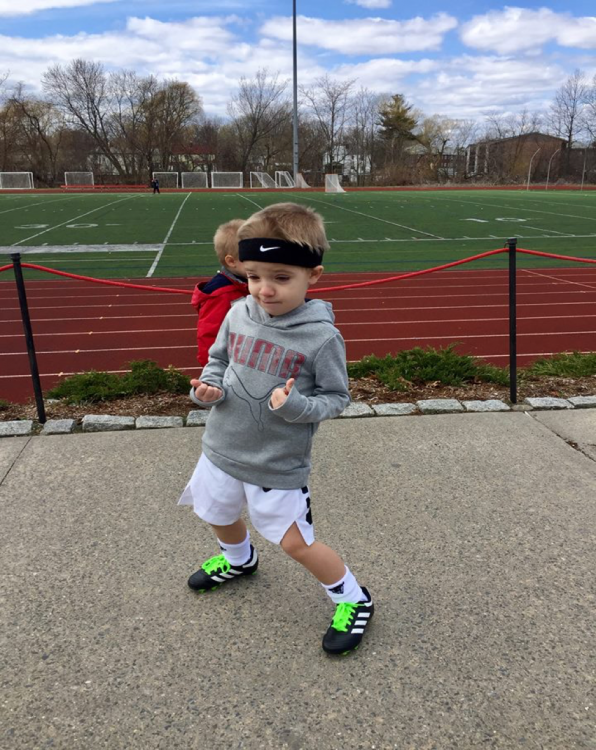 boy near a track, doing "thumbs up"