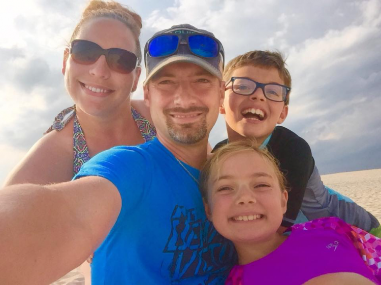 family smiling on the beach