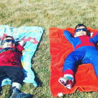 two brothers smiling, laying on the ground