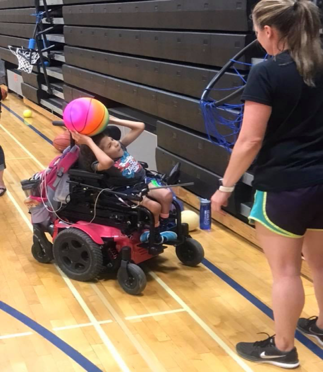 girl in wheelchair playing with a ball