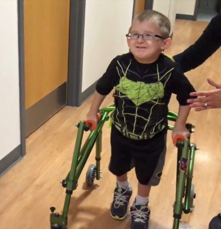 little boy walking with walker