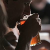 close up photo of man drinking pint of beer