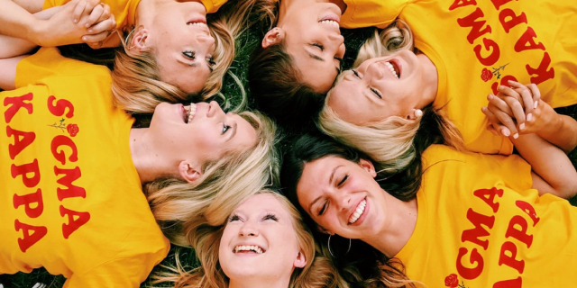 Talkspace Provides Tele-Therapy to Sigma Kappa Sorority Members Across the U.S. Sigma Kappa members laying in grass with yellow shirts with red letter that says "Sigma Kappa."