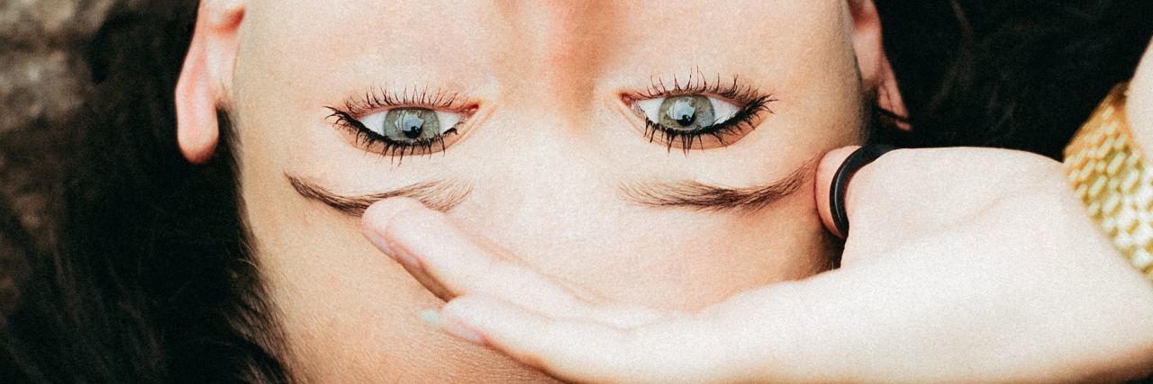 Daily Thoughts I Have as a Person With Anxiety woman looking up at camera with hand on forehead