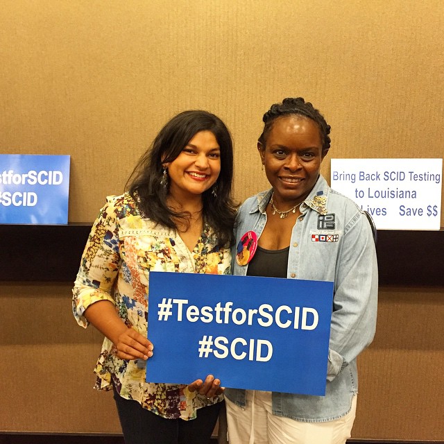 two women holding a sign "test for SCID"