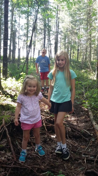 Three siblings in the woods playing